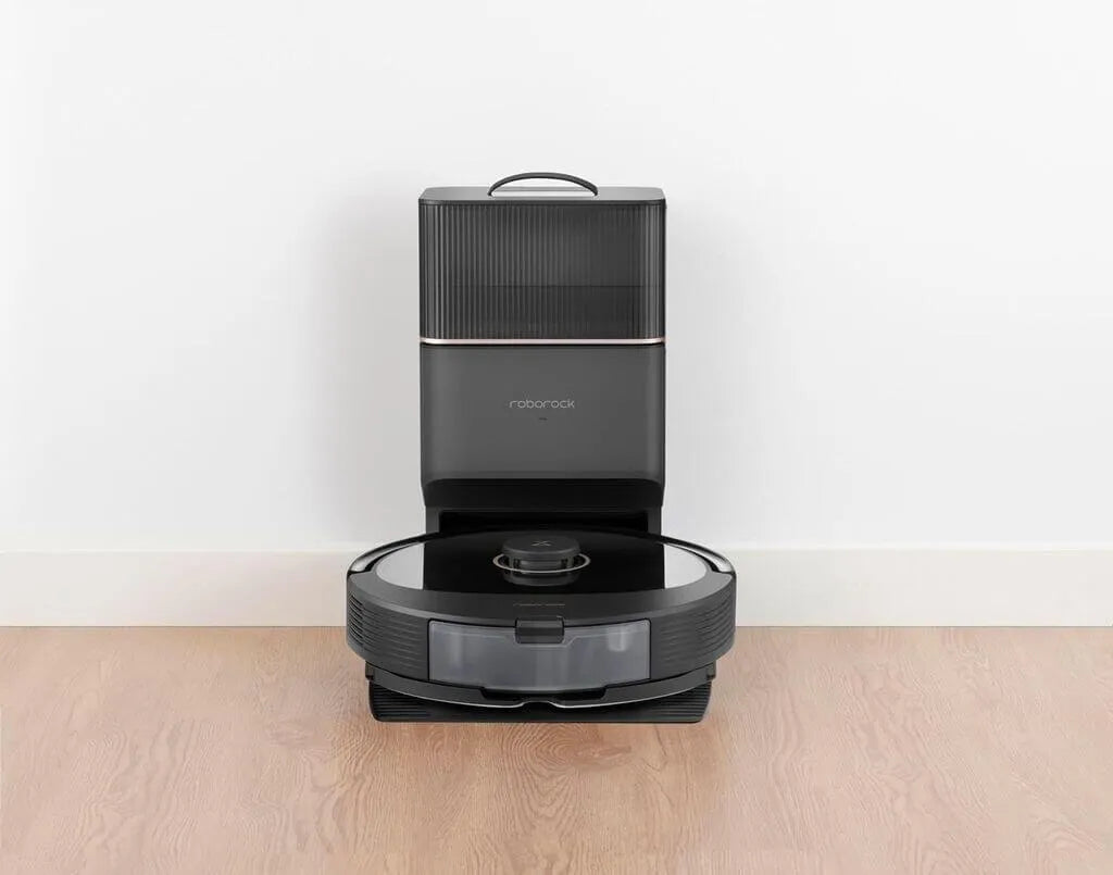 Robotic vacuum cleaner on a wooden floor with a white wall background